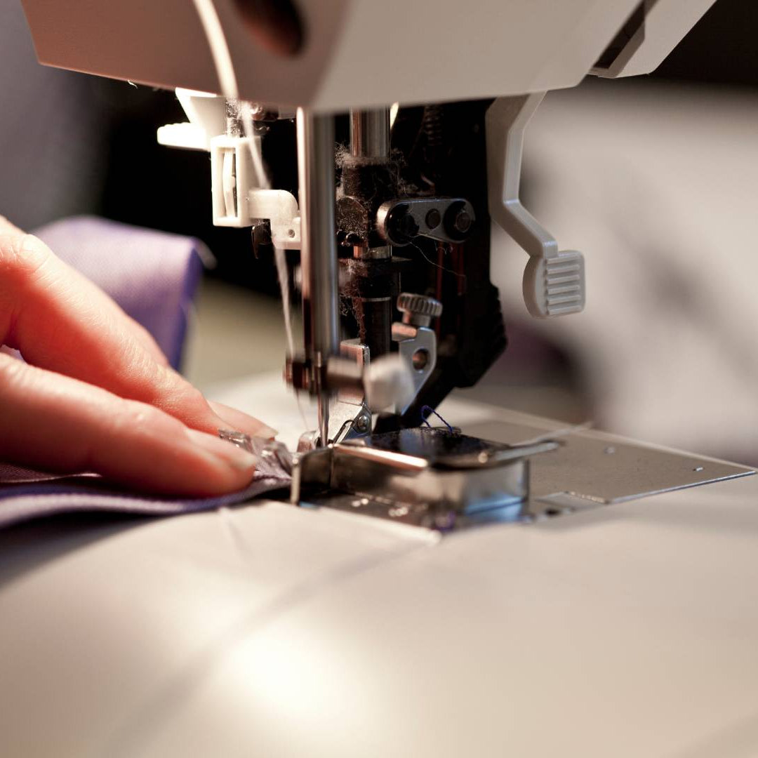 Nahaufnahme einer Nähmaschine beim Vernähen von Musselin Stoff – perfekte Basis für DIY Stoffservietten