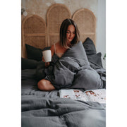 Musselin-Bettwäsche Farbe Anthrazit Frau auf Bett