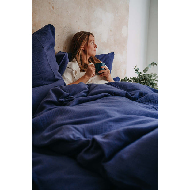 Musselin-Bettwäsche Farbe Indigo Frau auf Bett