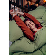Musselin-Kopfkissen in der Farbe Basil Moodbild 02 Frau in Bett