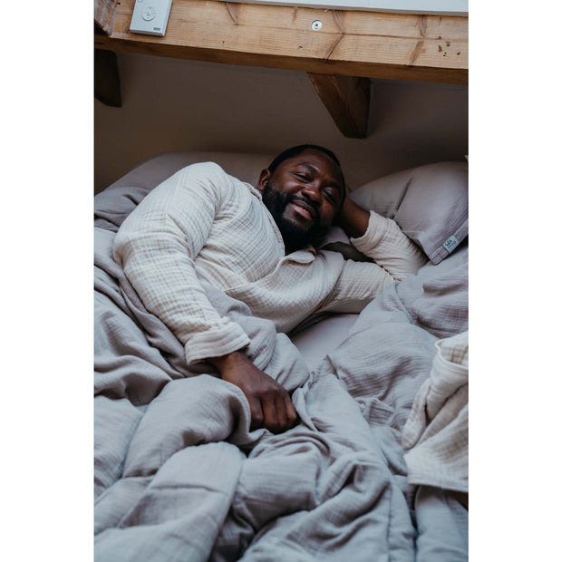 Musselin-Kopfkissen in der Farbe Stein Moodbild 02 Mann in Bett