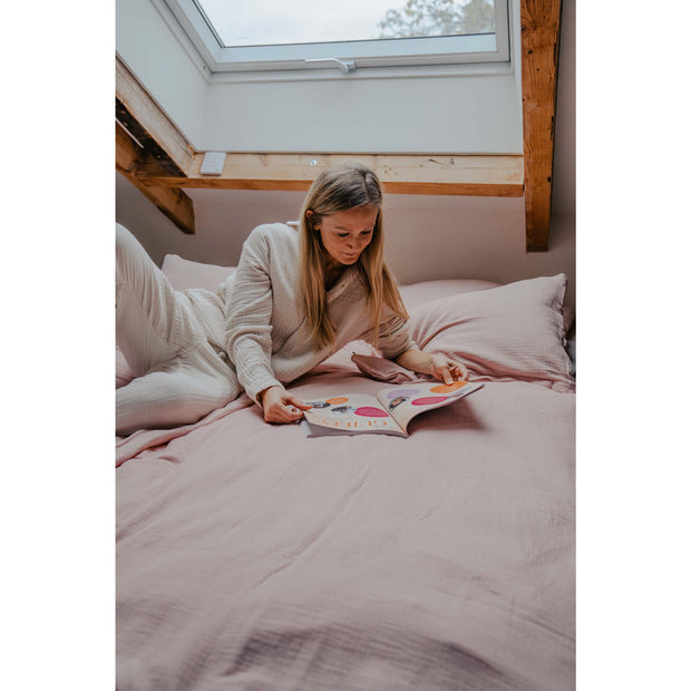 Musselin-Pyjama in der Farbe Beige Frau liegt auf Bett